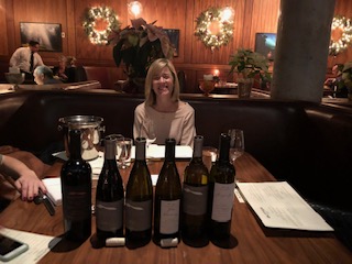 Courtney Foley of Chalk Hill Estate Winery sitting with her wine bottles